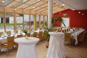 un salón de banquetes con mesas y sillas blancas en Hotel Kartause en Gaming