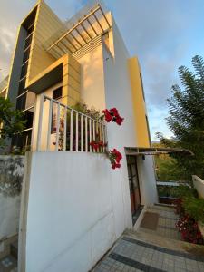 a house with a balcony with flowers on it at Munnar BnB in Munnar