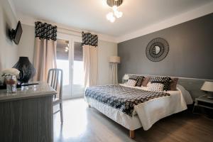 a bedroom with a bed and a table and a mirror at Hôtel Spunta Di Mare in Ajaccio