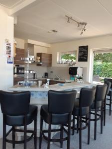 a kitchen with a bar with chairs around it at B&B De Kandelaar in Biddinghuizen