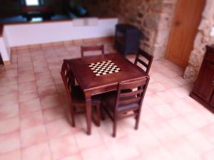 une table et des chaises en bois avec un jeu de société. dans l'établissement Quinta da Gandra, à Paredes de Coura