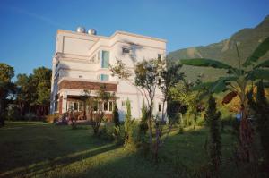 a large white building with trees in front of it at ShiGuo Homestay in Xiulin