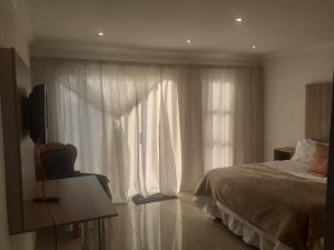 a bedroom with a bed and a large window at Lesiba guesthouse in Kwamhlanga
