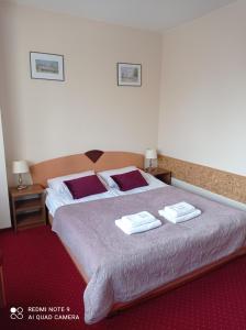 a bedroom with a large bed with two towels on it at Harmonia in Biała Podlaska