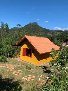 una pequeña casa amarilla con techo rojo en Canto da Colina Lumiar, en Lumiar