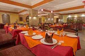 a restaurant with long tables with red table cloths at Hotel Rajmahal in Guwahati