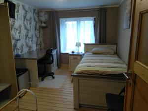 1 dormitorio con cama, escritorio y ventana en Logies 't Eenvoud (rooms) en Knokke-Heist