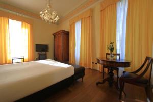 a bedroom with a bed and a table and a chandelier at Classique in Lazise