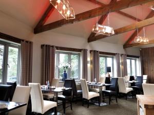 a dining room with tables and chairs and windows at The White Hart in Swindon