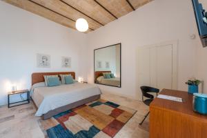 a bedroom with a bed and a mirror and a desk at Villa Torre Bianca by Emily Hotels in Polignano a Mare