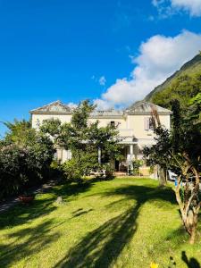 une grande maison blanche avec une cour verdoyante dans l'établissement Relais Des Gouverneurs, à Salazie