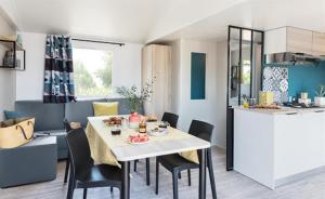 a kitchen and dining room with a table and chairs at Camping Pen Guen in Saint-Cast-le-Guildo