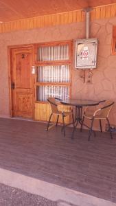 a patio with a table and chairs and a window at La Tribu del Indio, Desayuno Incluido in San Pedro de Atacama