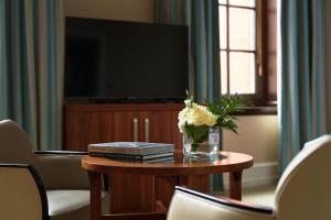 a vase of flowers on a table with a television at The Grand, York in York