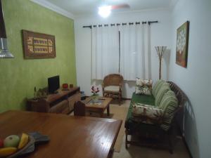 a living room with a couch and a dining room table at Apartamento em Boracéia no Litoral Norte in Bertioga