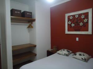 a bedroom with a bed and a painting on the wall at Apartamento em Boracéia no Litoral Norte in Bertioga +14 photos