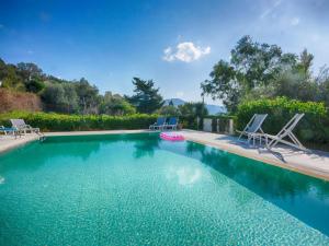 a swimming pool with two lounge chairs and a swimming pool at Villa Afionas - 3 minutes from the beach with heated Eco-Pool and Sunset view in Afionas