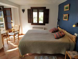a bedroom with a large bed with blue walls at Casa Rural Arroyo de la Greda in Güéjar-Sierra
