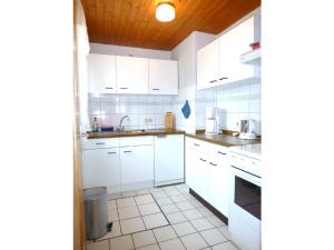 a white kitchen with white cabinets and a sink at Ferienhaus Mahlertsmühle in Hofbieber