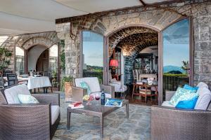 a living room with chairs and a stone wall at Lubra Casa Relax in Massa Lubrense