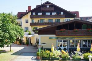 ein großes Gebäude mit vielen Pflanzen davor in der Unterkunft Attergauhof in Sankt Georgen im Attergau