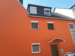 un bâtiment orange avec un toit noir dans l'établissement Ferienwohnung Sabine, à Coblence