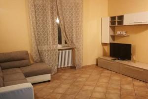 een woonkamer met een bank en een televisie bij "La ca` 'd Giaculin" -Casetta indipendente in Magliano Alpi