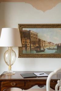 a lamp on a desk with a picture on the wall at Hotel Cipriani, A Belmond Hotel, Venice in Venice