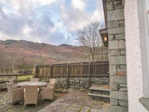 a patio with a table and chairs and a fence at Plumblands in Ambleside