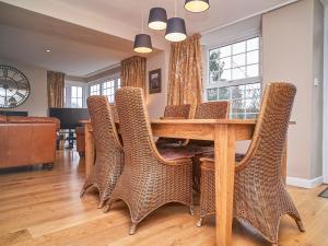 a dining room with a wooden table and wicker chairs at Plumblands in Ambleside