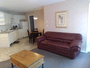 sala de estar con sofá de cuero marrón y cocina en Fairmont Mountain View Villas, en Fairmont Hot Springs