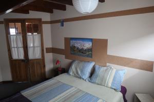 1 dormitorio con 1 cama con almohadas azules en Casa Andina Chaltén en El Chaltén
