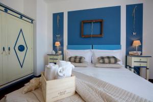 a bedroom with a large bed with blue walls at Hotel Pocho in San Vito lo Capo