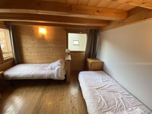 een kamer met 2 bedden in een blokhut bij Boost Your Immo Le Mélezet Vars 416 in Vars