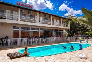 a group of people in a swimming pool in front of a hotel at Leme Plaza Hotel in Leme