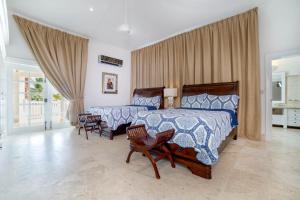 1 dormitorio con 2 camas y 2 sillas en Paradise Luxury Villa with Huge Pool and Jacuzzi en Punta Cana