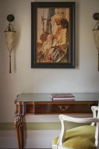 a painting hanging on a wall with a table at Hotel Cipriani, A Belmond Hotel, Venice in Venice