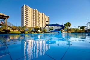 une piscine avec toboggan en face d'un bâtiment dans l'établissement Golden Dolphin Express via Giro ImobTech, à Caldas Novas