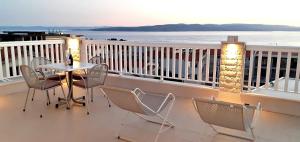 balkon ze stołem i krzesłami oraz oceanem w obiekcie Apartments Villa Bonaca w Baskiej Vodzie