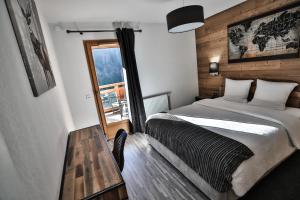 サン・ジャン・ド・シックスにあるAppt Primevères - Centre village, Vue montagne - AravisTourのベッドルーム1室(ベッド1台、テーブル、窓付)