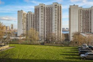 a view of tall buildings with cars parked in a field at Hotel Strogino Expo in Moscow