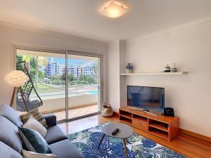 sala de estar con sofá y TV de pantalla plana en Aidan Apartment by LovelyStay en Funchal