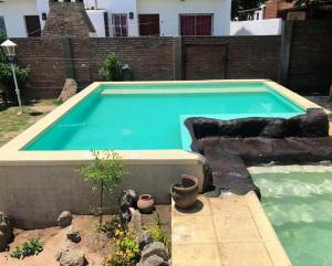 una gran piscina en un patio con macetas en Cabaña El Descanso en Villa Carlos Paz