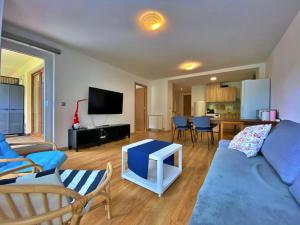 un soggiorno con divano blu e tavolo di Ribasol 645, apartamento hasta 4 personas, Arinsal ad Arinsal