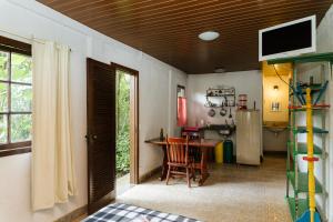 a living room with a table and a kitchen at Chalés do Beto em Macacos in Macacos