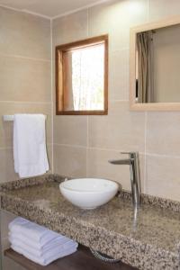 a bathroom with a white sink and a mirror at Cabañas "Las Escondidas" in Valle Grande