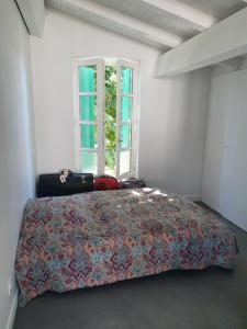 a bedroom with a bed and a window at Appartement le Pas Sage du Marché La Flotte in La Flotte