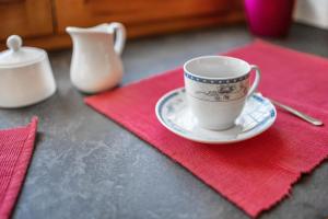 una tazza su un piatto su un tovagliolo rosso di Appartamento Mariagrazia a Tesero