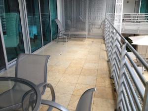 Un balcón con sillas y mesas y un suelo. en Apartment at De Soleil Hotel on Ocean Drive, en Miami Beach