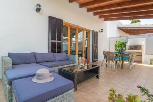 een woonkamer met een blauwe bank en een tafel bij Casa Hector in Cala Ferrera